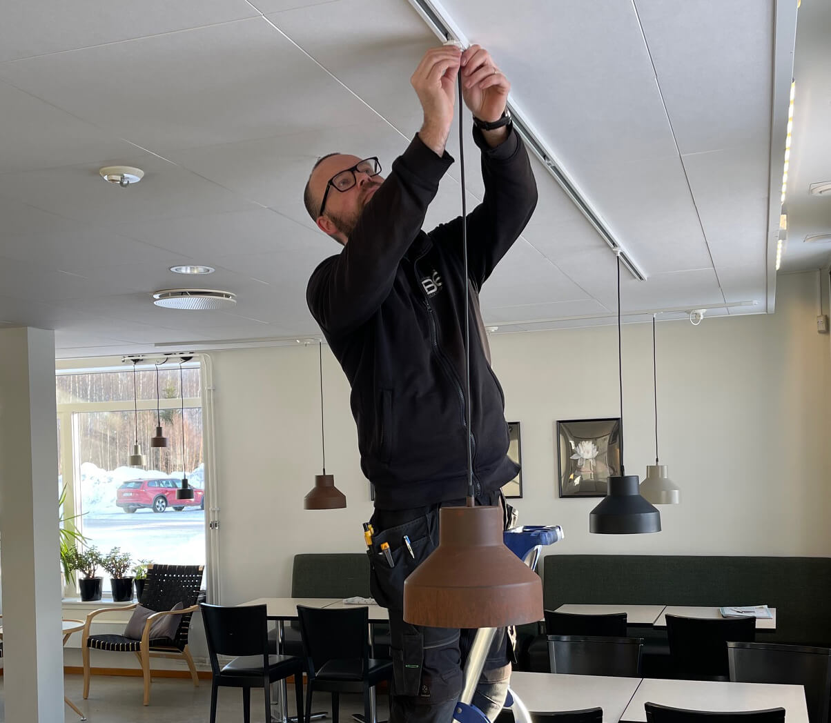 Arvid Brändström, elektriker i Sävar, skruvar fast armaturer